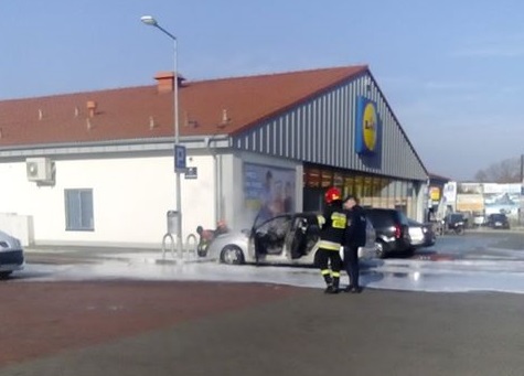 Samochód palił się na parkingu przed sklepem. – Stwarzał zagrożenie dla innych aut – mówią strażacy