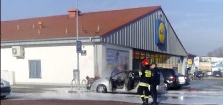 Samochód palił się na parkingu przed sklepem. – Stwarzał zagrożenie dla innych aut – mówią strażacy