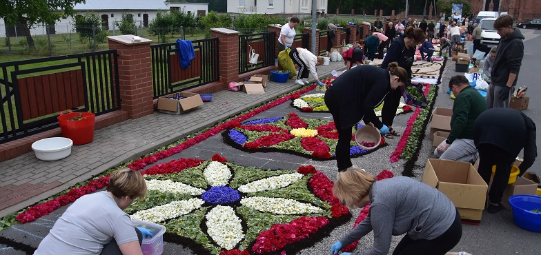 Układali kwietny dywan przy kościele. Dzisiaj Boże Ciało