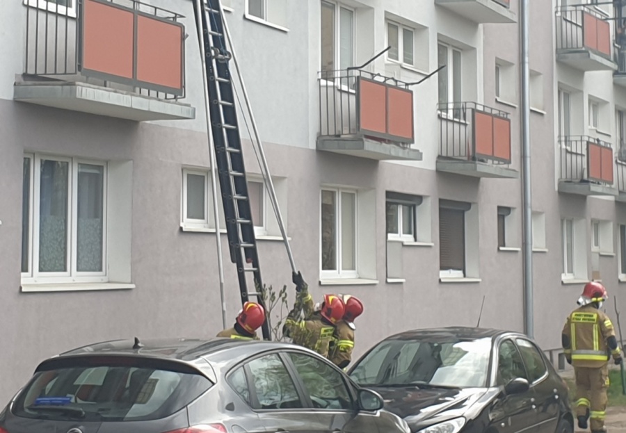 Strażacy i policjanci przy bloku. Kobieta była zaskoczona interwencją 