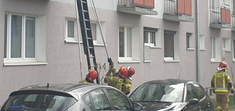 Strażacy i policjanci przy bloku. Kobieta była zaskoczona interwencją 