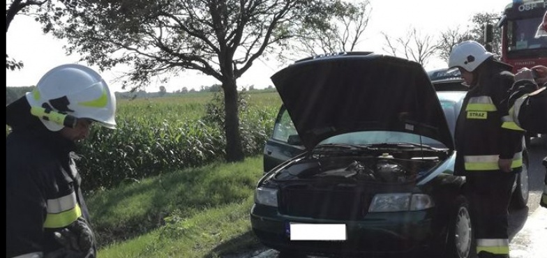 Auto paliło się na krajówce. Strażacy zepchnęli je w boczną drogę