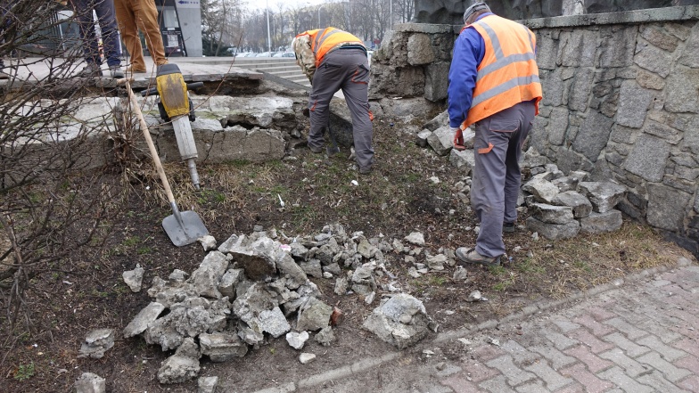 W Koninie przy ulicy Dworcowej runął mur oporowy przy chodniku. Robotnicy usuwają gruz 